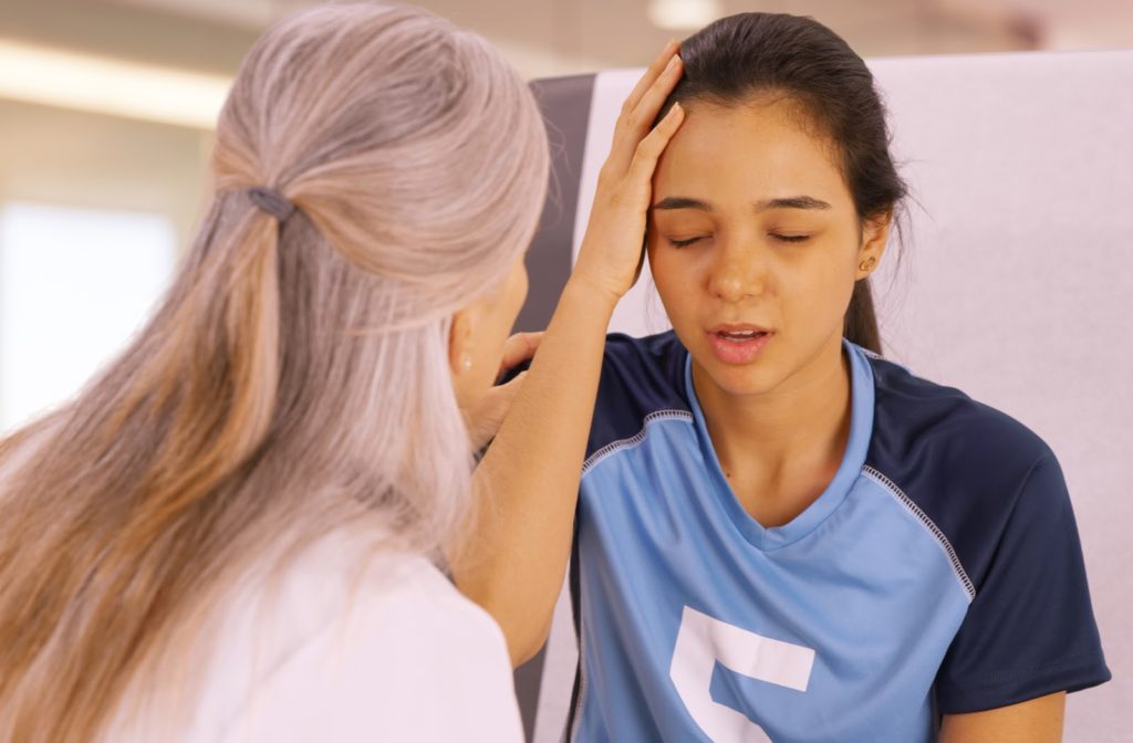 A young girl who is concussed from playing soccer seeking help at a doctors office