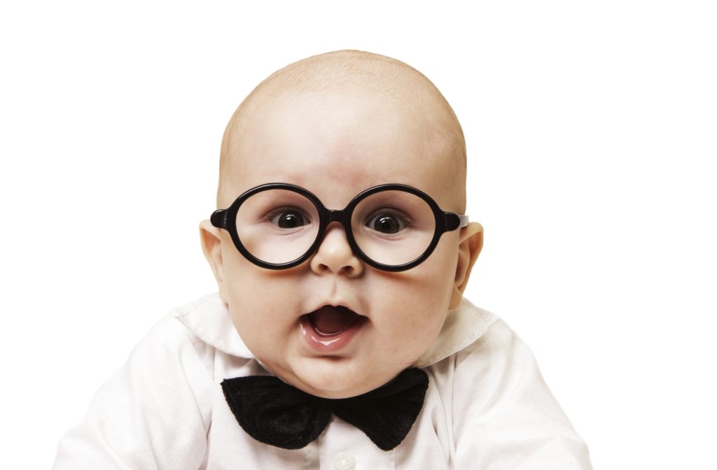 A baby wearing a pair of black glasses and a black bowtie with a white button shirt