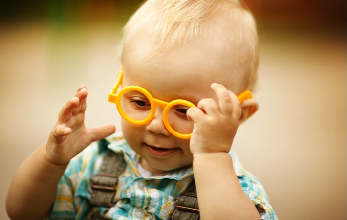 A little boy wearing his first pair of yellow glasses