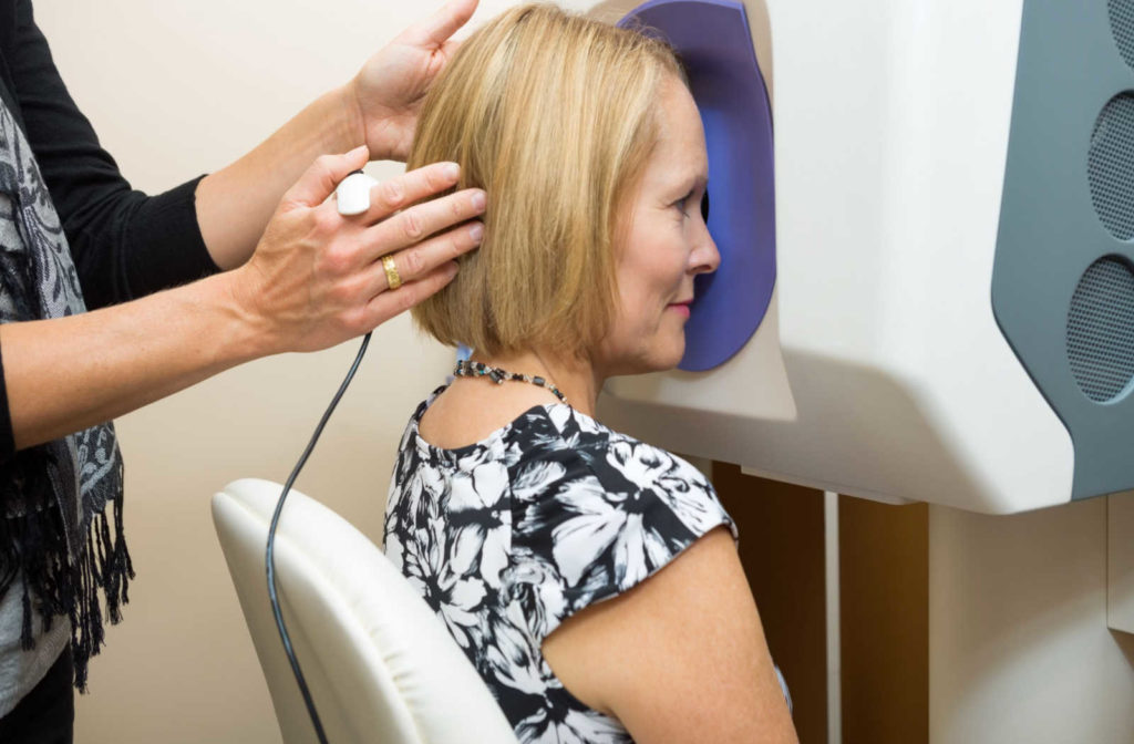 A woman has her head held in the correct position in preparation for retinal imaging.