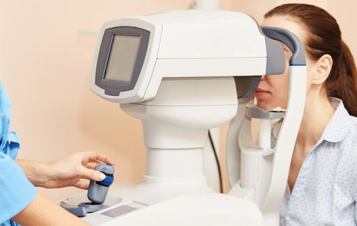 A woman at the eye doctor getting an OCT test during her eye exam to help detect eye diseases such as macular degeneration and glaucoma.