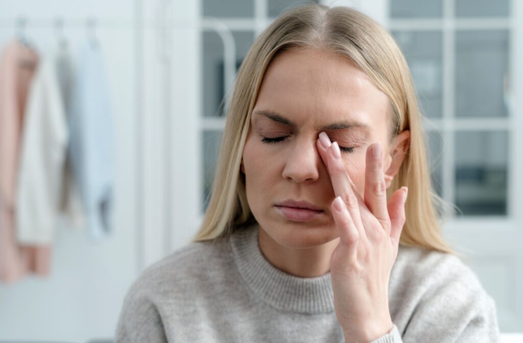 A person rubbing their eyes in frustration in the morning, wondering about how to find relief from their dry eyes.