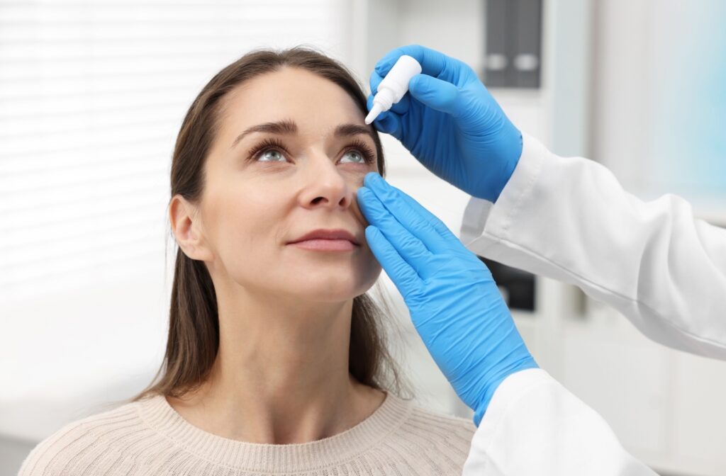 Doctor applying eye drops to a woman's eyes to alleviate dry eyes.