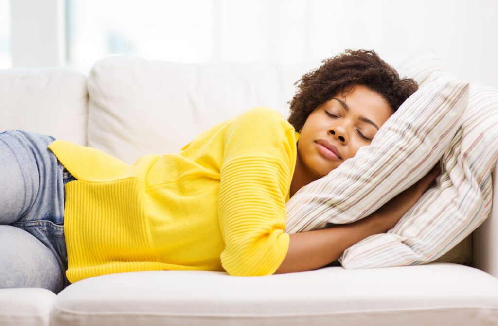 A person has fallen asleep on the couch while wearing contact lenses.