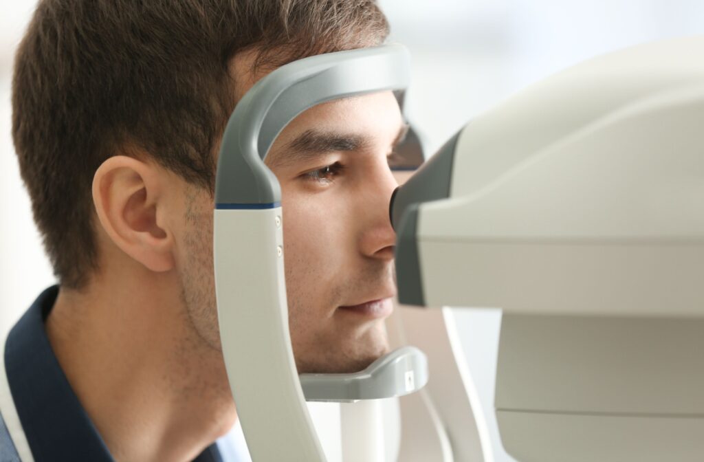 An adult patient rests their chin in tonometer machine as their eye doctor measures their eye pressure.