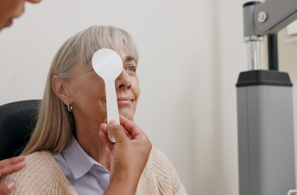 A woman sitting in an eye exam chair during a check-up after noticing the first signs of cataracts.
