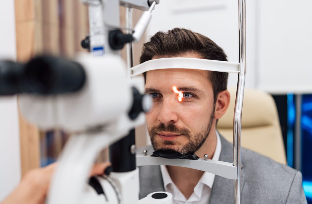 A patient sitting in an eye exam chair as a laser is being used during their annual eye exam.