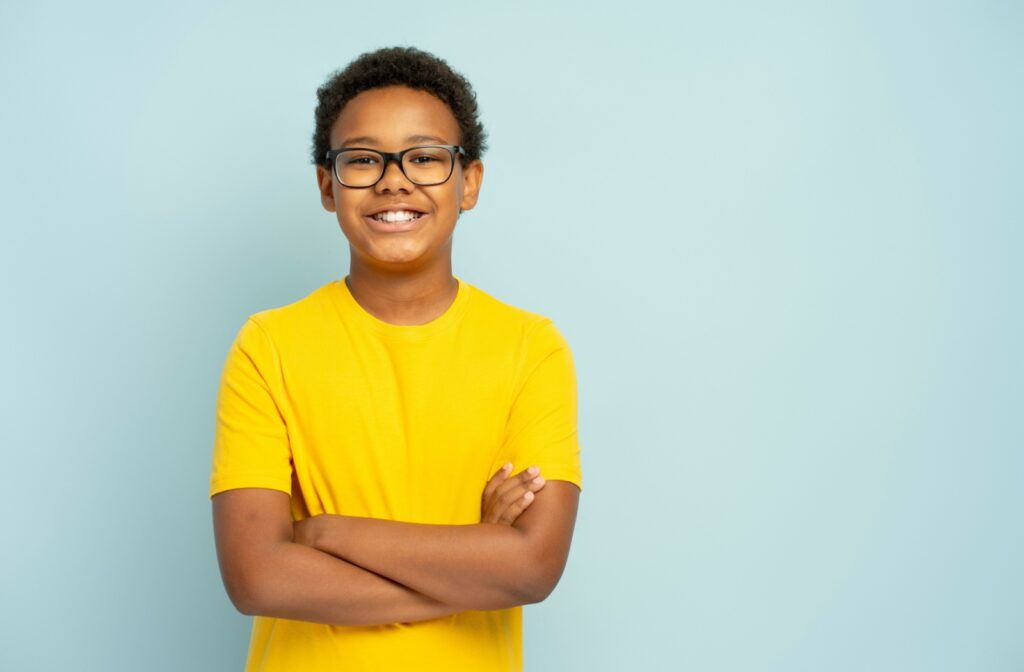 Child with myopia wearing glasses and a yellow shirt.