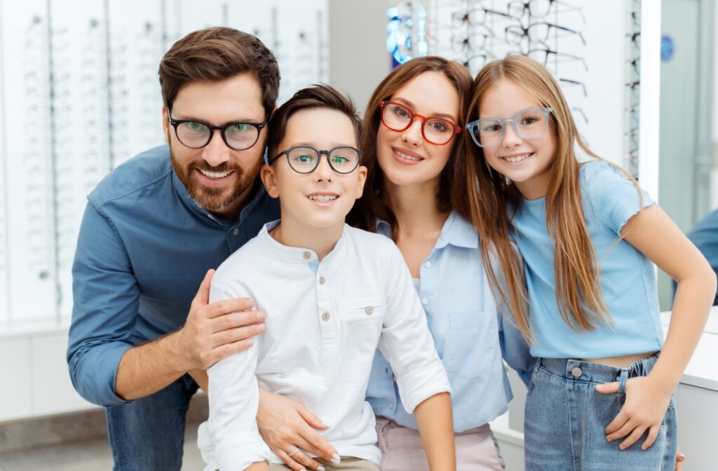 a mom, dad, son, and daughter all wearing glasses together looking at the camera.