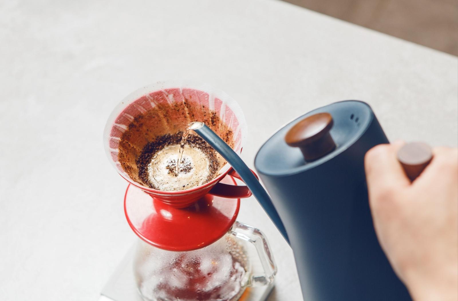 coffee being poured over a coffee strainer